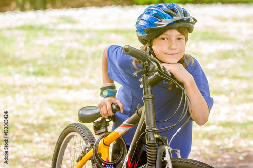 young happy preteen child boy riding a bicycle on natural park b