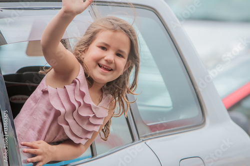 portrait of young happy smiling child girl traveling by car and © Alena Yakusheva