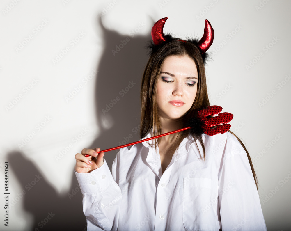 young girl in a man's white shirt with red horns looks like pretty Devil young girl in a man's white shirt with red horns looks like pretty Devil