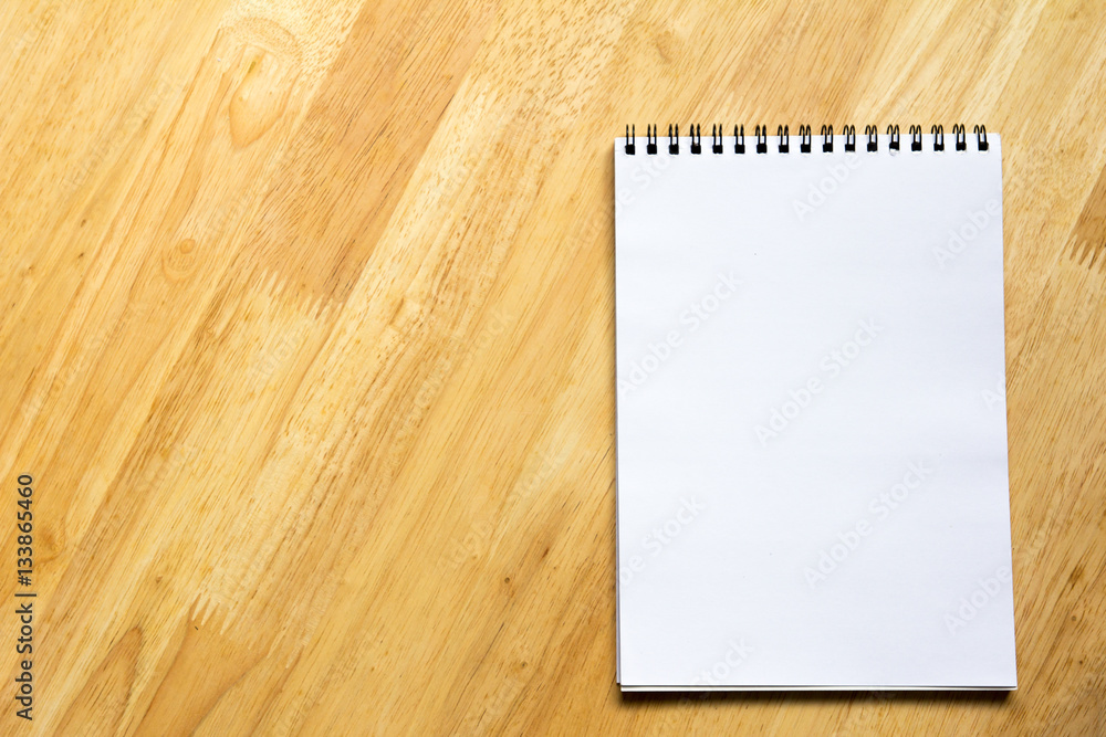 White note book place on wooden table background White note book place on wooden table background
