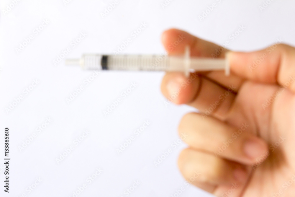 Blur background of Man hold the plastic syringe Blur background of Man hold the plastic syringe