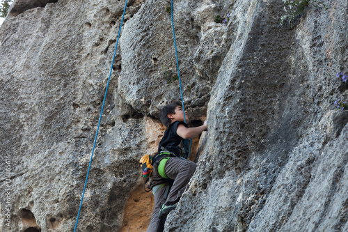 Boy climbing on a limestone wall
