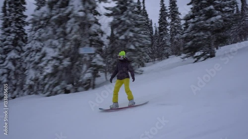 Wallpaper Mural Young woman is drifting a snowboard fast on the snow-covered slope at winter cloudy day Torontodigital.ca