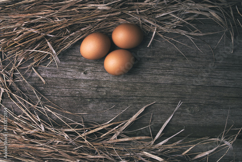 chicken eggs on old wooden table, rustic background