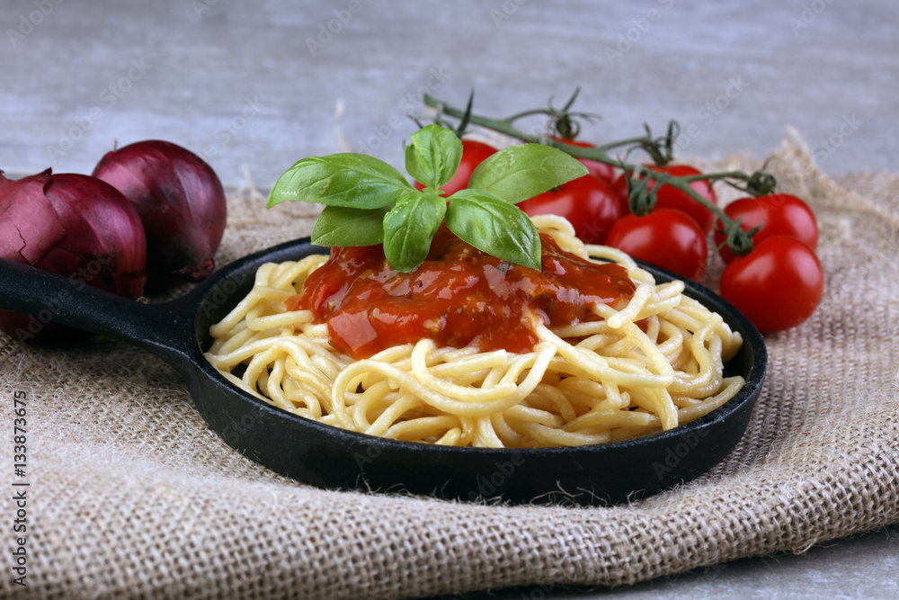 Plate of delicious spaghetti Bolognaise or Bolognese with savory minced beef and tomato sauce garnished with parmesan cheese and basil Plate of delicious spaghetti Bolognaise or Bolognese with savory minced beef and tomato sauce garnished with parmesan cheese and basil