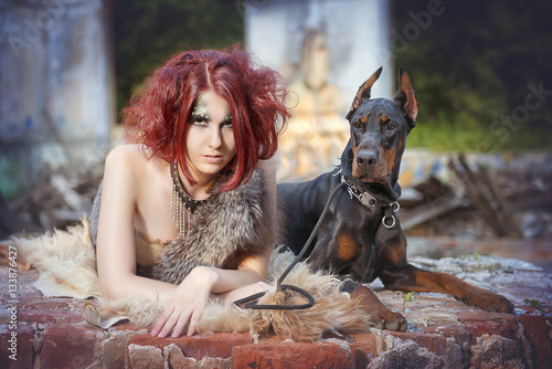 Girl Amazon with Dobermans in the ruins of an old house