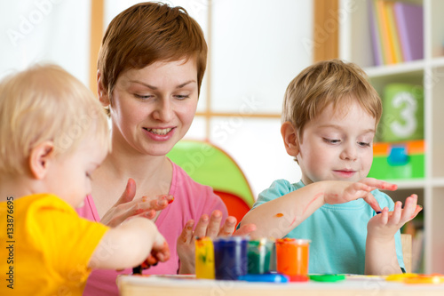 Kids with teacher painting ...