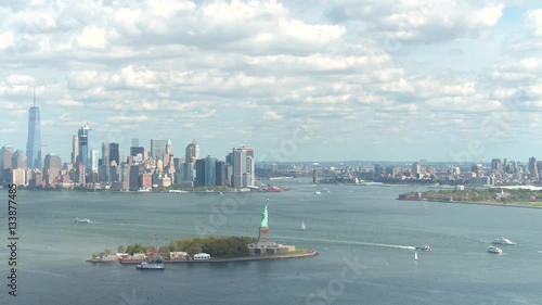 AERIAL: Flying towards Lady Liberty statue in front of New York city skyline