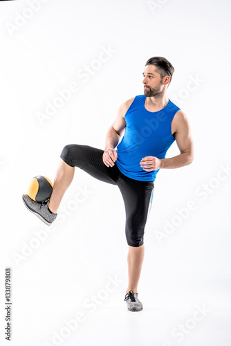 Man exercising with ball © LIGHTFIELD STUDIOS