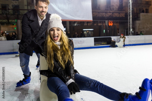 Принти на полотні Beautiful young couple ice skating on rink outdoors.