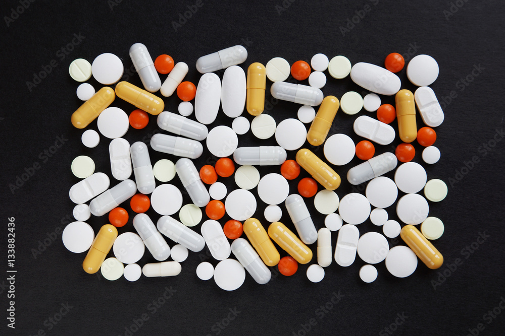 Many various pills and tablets as square lie on black background Many various pills and tablets as square lie on black background