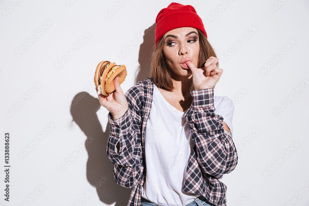 Hungry young lady eating burger