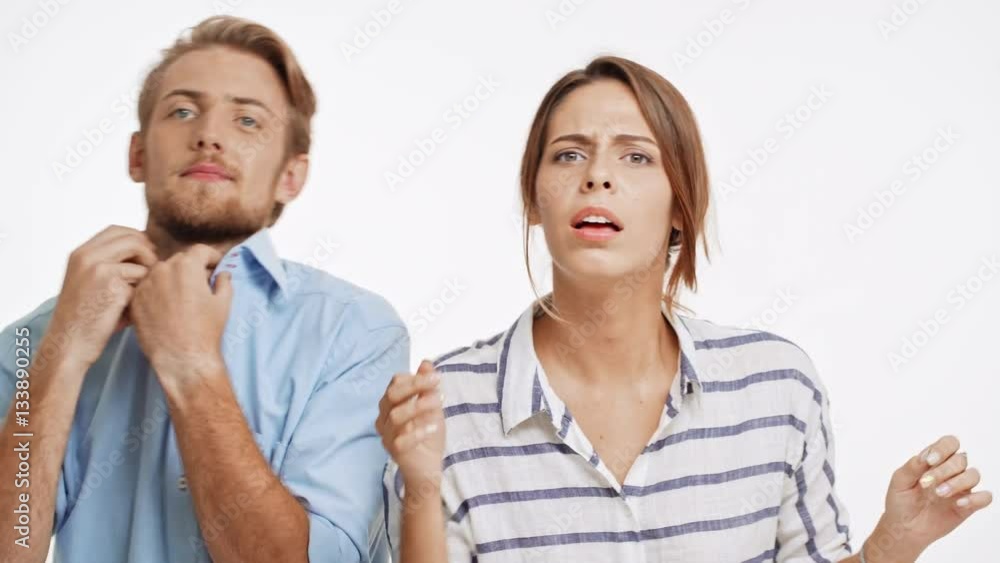 Caucasian young couple freshens up in front of camera and push each other on white background Caucasian young couple freshens up in front of camera and push each other on white background