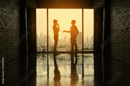 Two businessmen are negotiating business in office on the building. photo