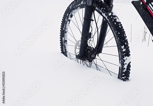 The front wheel of mountain bike stay in powder snow. Lost path © rdonar
