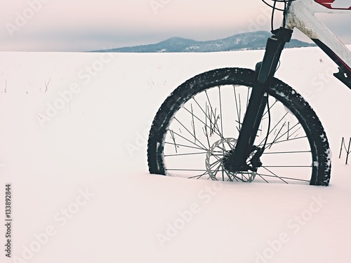 The front wheel of mountain bike stay in powder snow. Lost path © rdonar