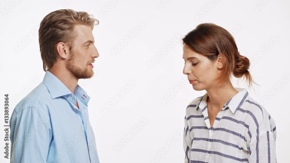 Young Caucasian pair playinf rock-paper-scissor on white background. Then laughing Young Caucasian pair playinf rock-paper-scissor on white background. Then laughing