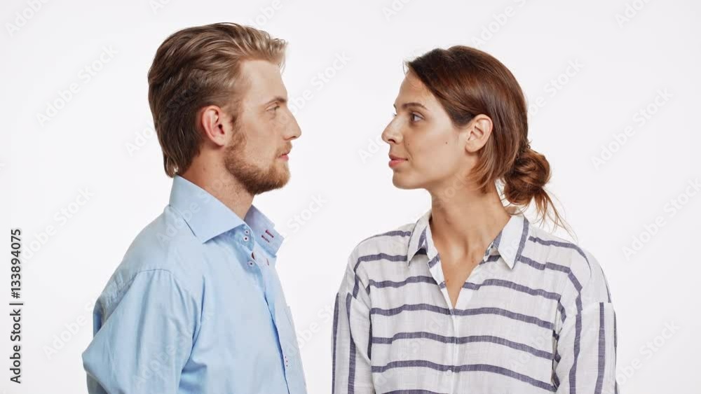 Beautiful Caucasian couple talking and surprisingly kissing on white background Beautiful Caucasian couple talking and surprisingly kissing on white background
