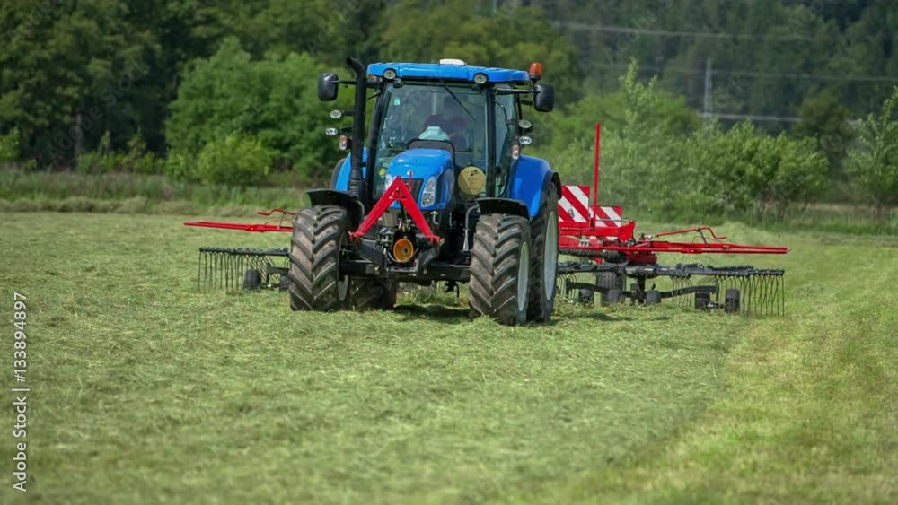 A young man puts one missing piece of the rotary hay rake back on its place. He looks quite tired because of the hard work and hot weather.
A young man puts one missing piece of the rotary hay rake back on its place. He looks quite tired because of the hard work and hot weather.