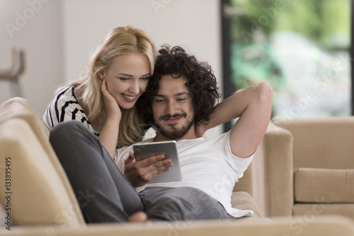 couple relaxing at  home with tablet computers