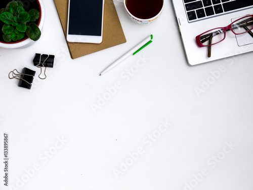 Modern white office computer Desk, mobile with a black screen on a laptop, and a Cup of tea. Top view with copy space, flat lay.