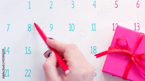 Hand marking celebration day on calendar page