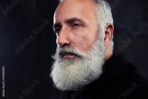 Indoors shot of stylish handsome adult man with gray long gray b