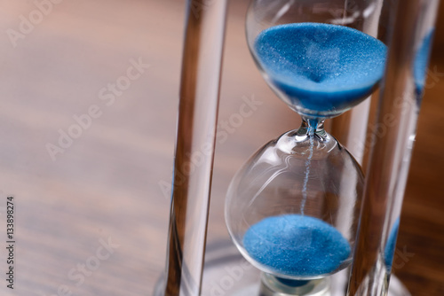 Classic hourglass with blue sand pouring