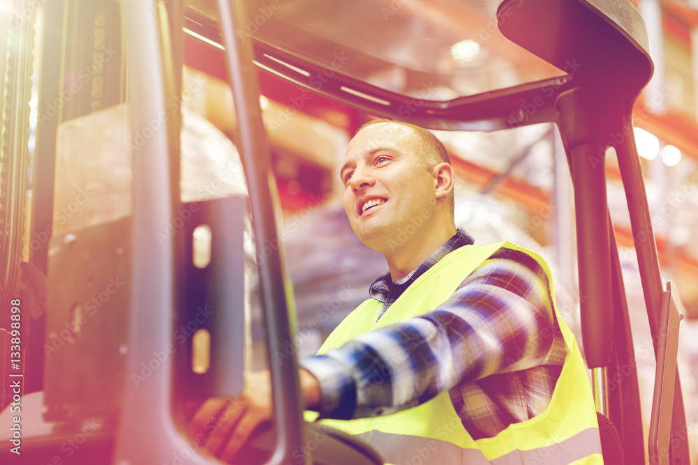 Obraz premium man operating forklift loader at warehouse