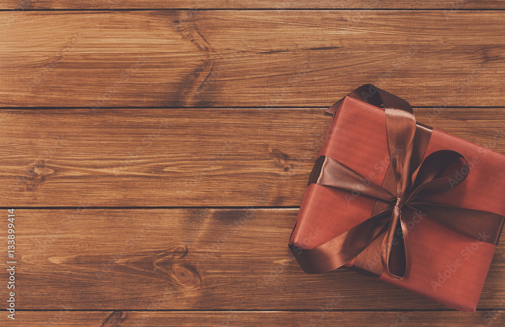 Present in gift box on wood background with copy space Present in gift box on wood background with copy space
