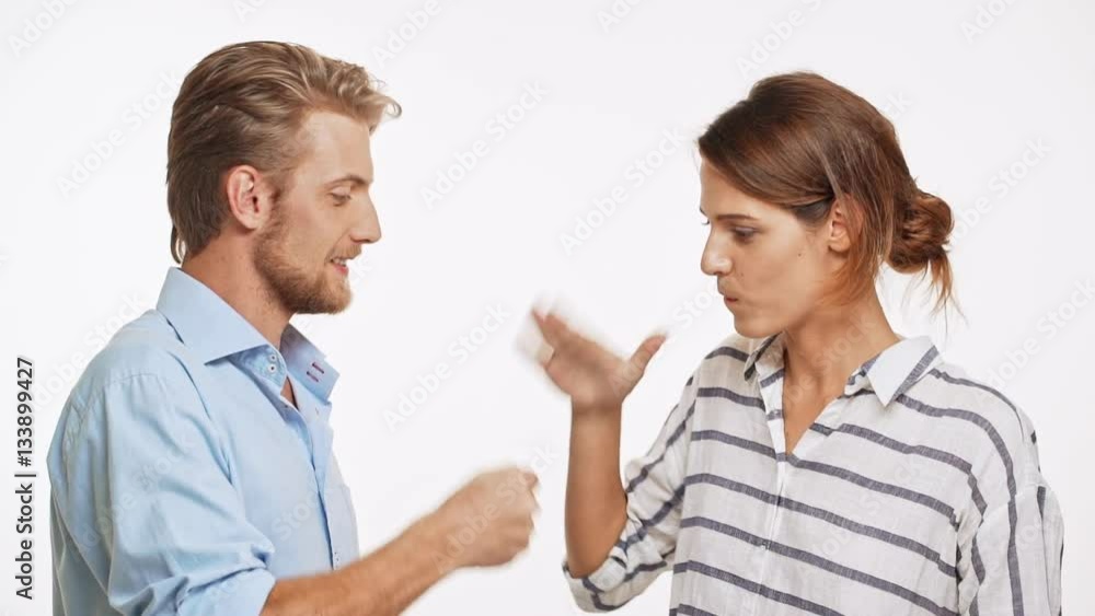 Young Caucasian pair playing rock-paper-scissor on white background in slowmotion and laughing Young Caucasian pair playing rock-paper-scissor on white background in slowmotion and laughing