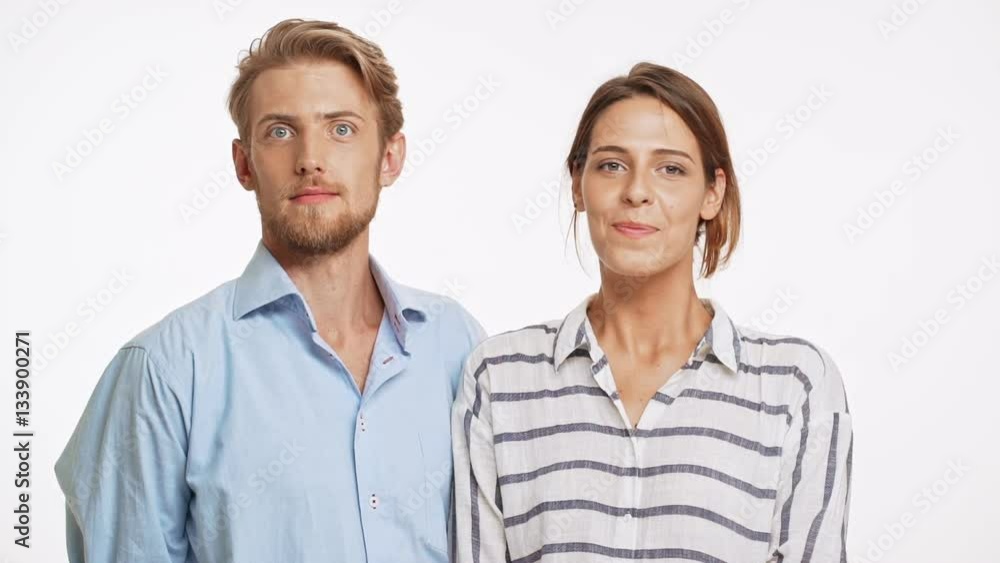 Beautiful Caucasian couple surprisingly kissing on white background in slowmotion Beautiful Caucasian couple surprisingly kissing on white background in slowmotion