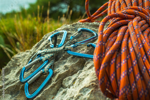 Safety harness with quick-draws and climbing equipment outdoor on a rock.