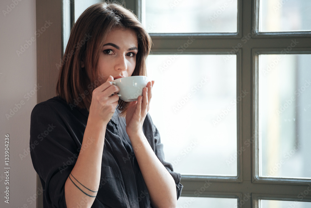 Young incredible cheerful woman drinking coffee. Young incredible cheerful woman drinking coffee.