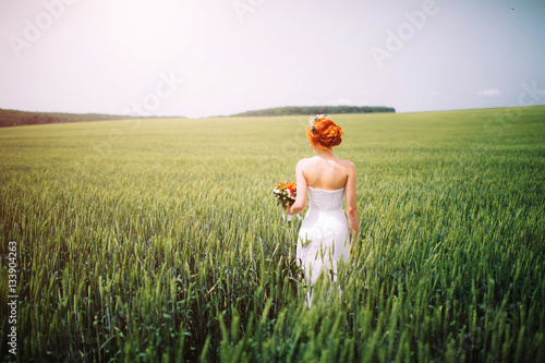 the bride with a bouquet on the green field