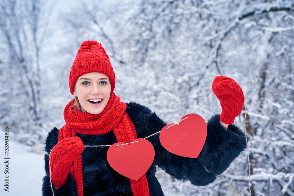 Love and valentines day concept. Happy excited woman holding garland of two red paper hearts shape - blank copy space for letters or text over winter landscape Love and valentines day concept. Happy excited woman holding garland of two red paper hearts shape - blank copy space for letters or text over winter landscape