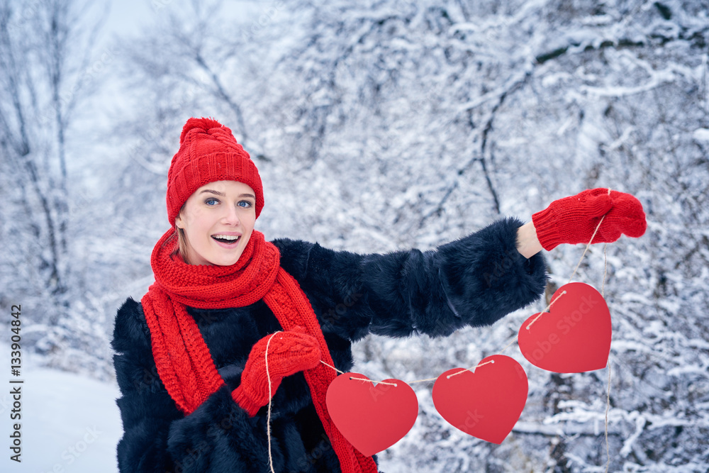 Love and valentines day concept. Happy excited woman holding garland of three red paper hearts shape - blank copy space for letters or text over winter landscape Love and valentines day concept. Happy excited woman holding garland of three red paper hearts shape - blank copy space for letters or text over winter landscape