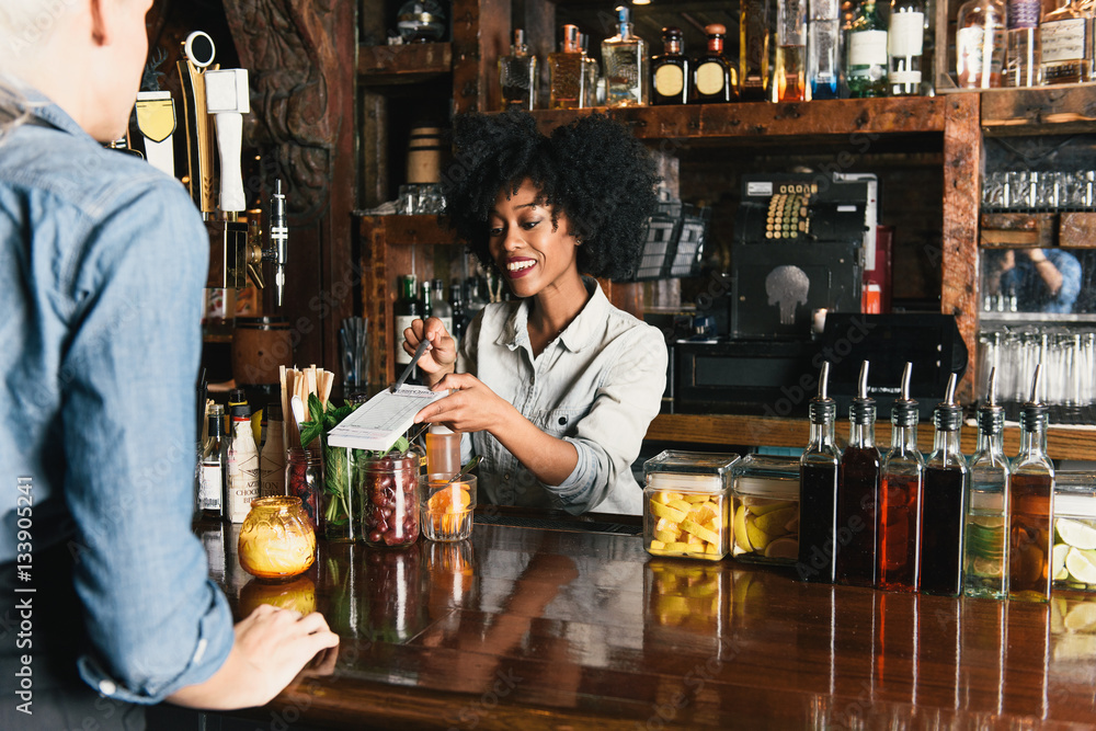 Bartender working behind bar in pub Stock Photo Adobe Stock