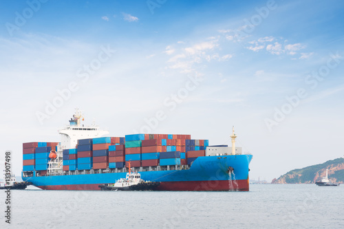 Container Cargo freight ship with working crane bridge in shipyard at dusk for Logistic Import Export background