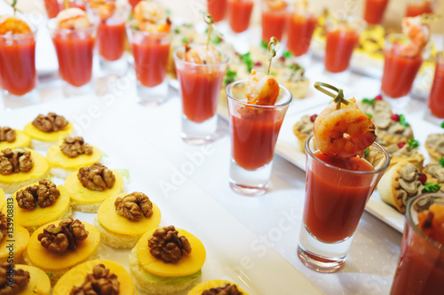 Seafood appetizer of shrimp and tomato sauce in a glass on a table.
