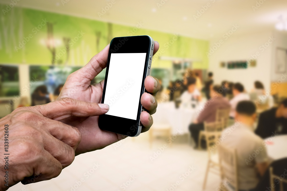 Man hand holding and using mobile,cell phone,smart phone with isolated screen with blur image of people for background.