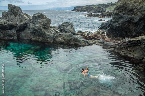 Father and daughter swimming in the natural swimming pool Charco De La Laja, at the north of Tenerife, Canary Islands, Spain