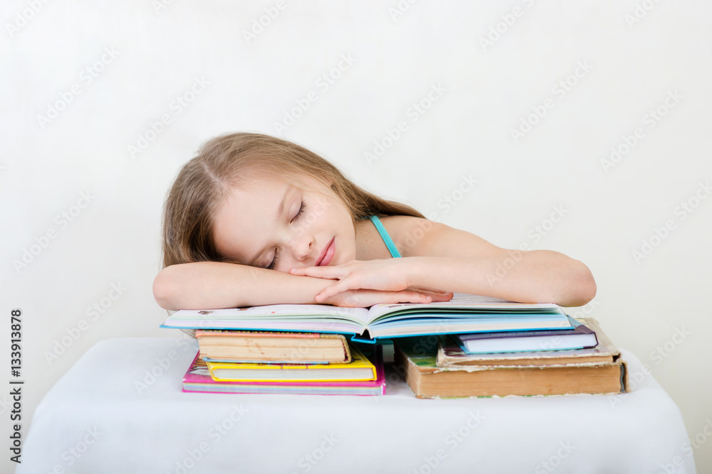 Little girl studying and reading book on light background. . Little girl studying and reading book on light background. .
