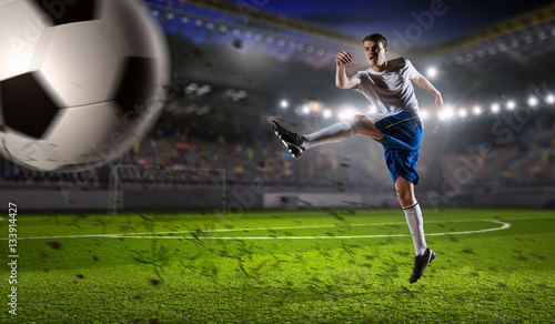 Soccer player at sport arena . Mixed media © Sergey Nivens