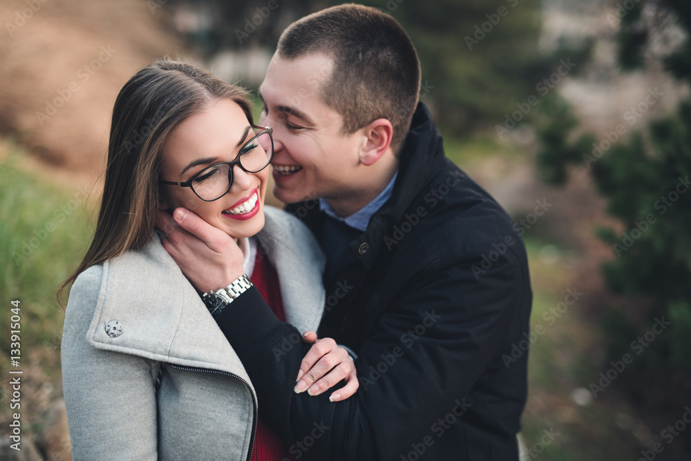 Beautiful middle age couple enjoying in love. They standing in city park, smiling and kissing. Close up shot. Beautiful middle age couple enjoying in love. They standing in city park, smiling and kissing. Close up shot.