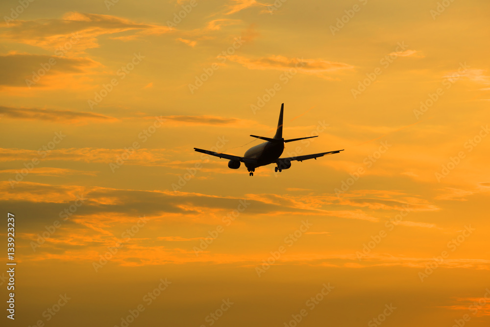 The evening sunset sky and flying away into the distance the aircraft. Heavenly landscape
