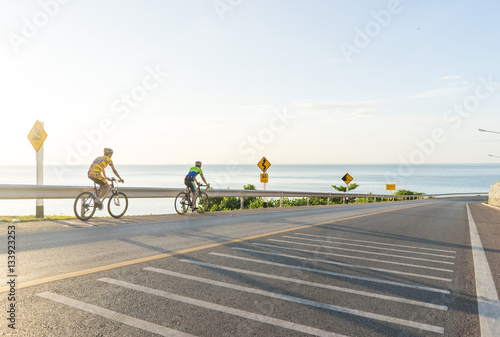 two Cyclists riding bicycles on the scenic route with ocean back