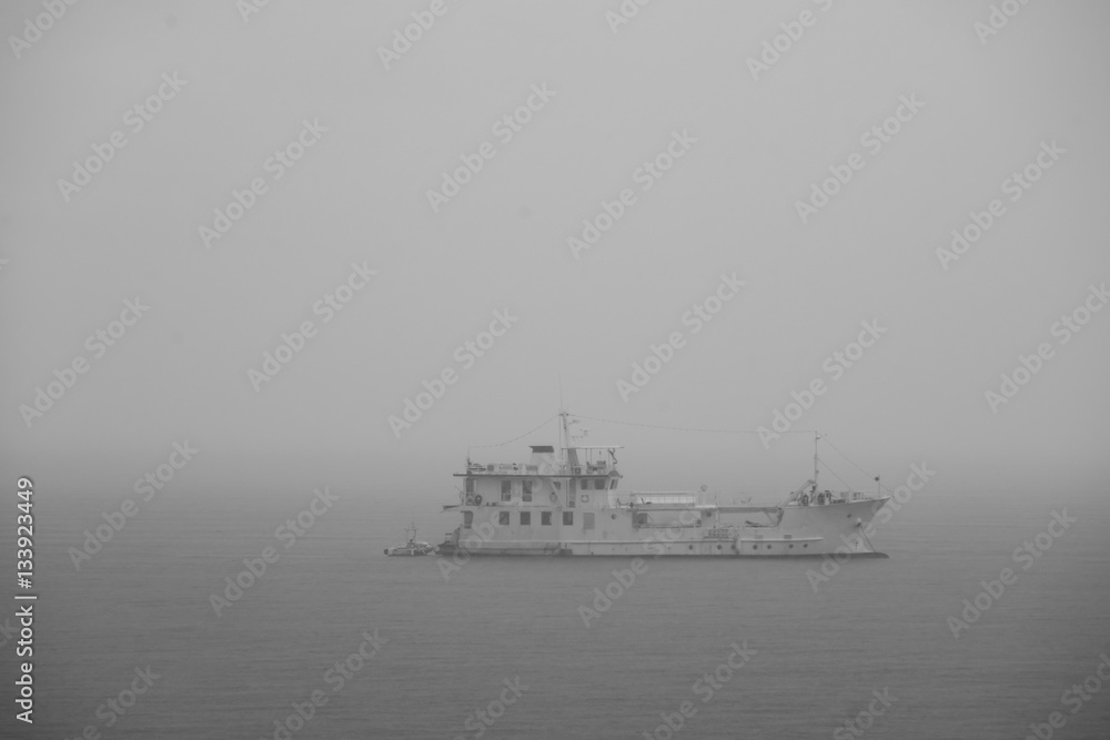 Yacht on the ocean in the foggy day in black and white tone