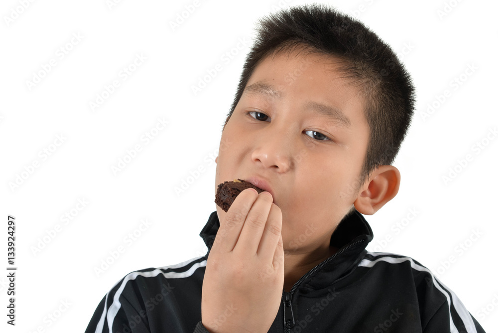Portrait of Asian boy eating brownie cake on white. Portrait of Asian boy eating brownie cake on white.