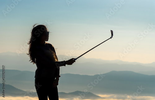 Silhouette of woman taking photos on the mountains. Filter effect style